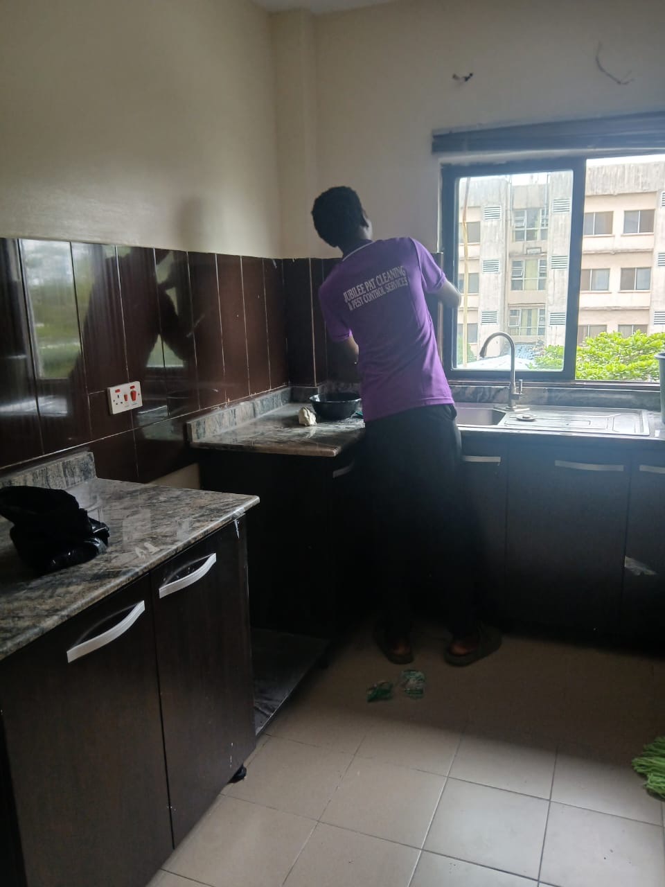 Cleaner detailing kitchen worktops and tiles